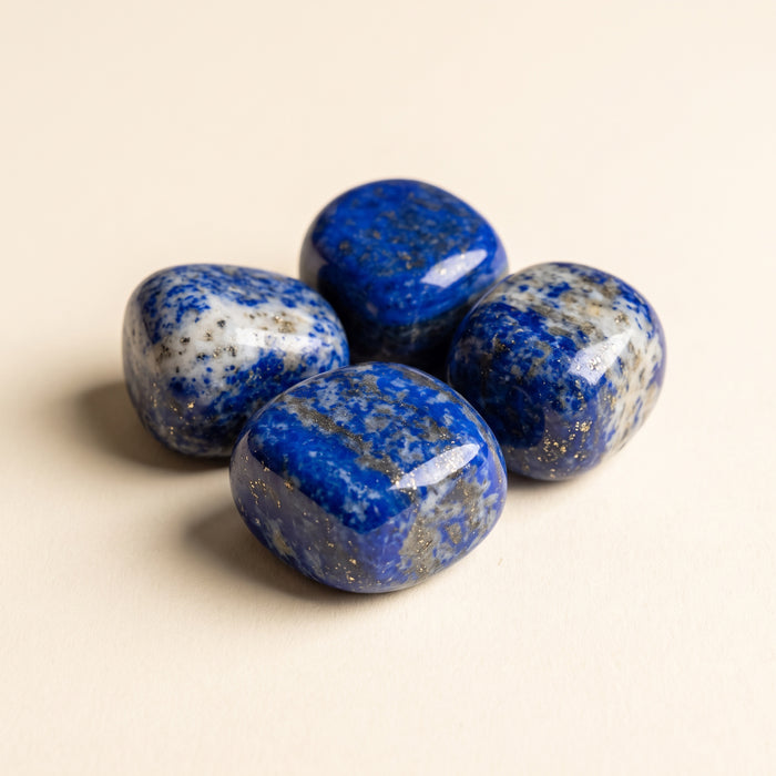 Polished lapis lazuli tumbled stones, deep blue with gold flecks