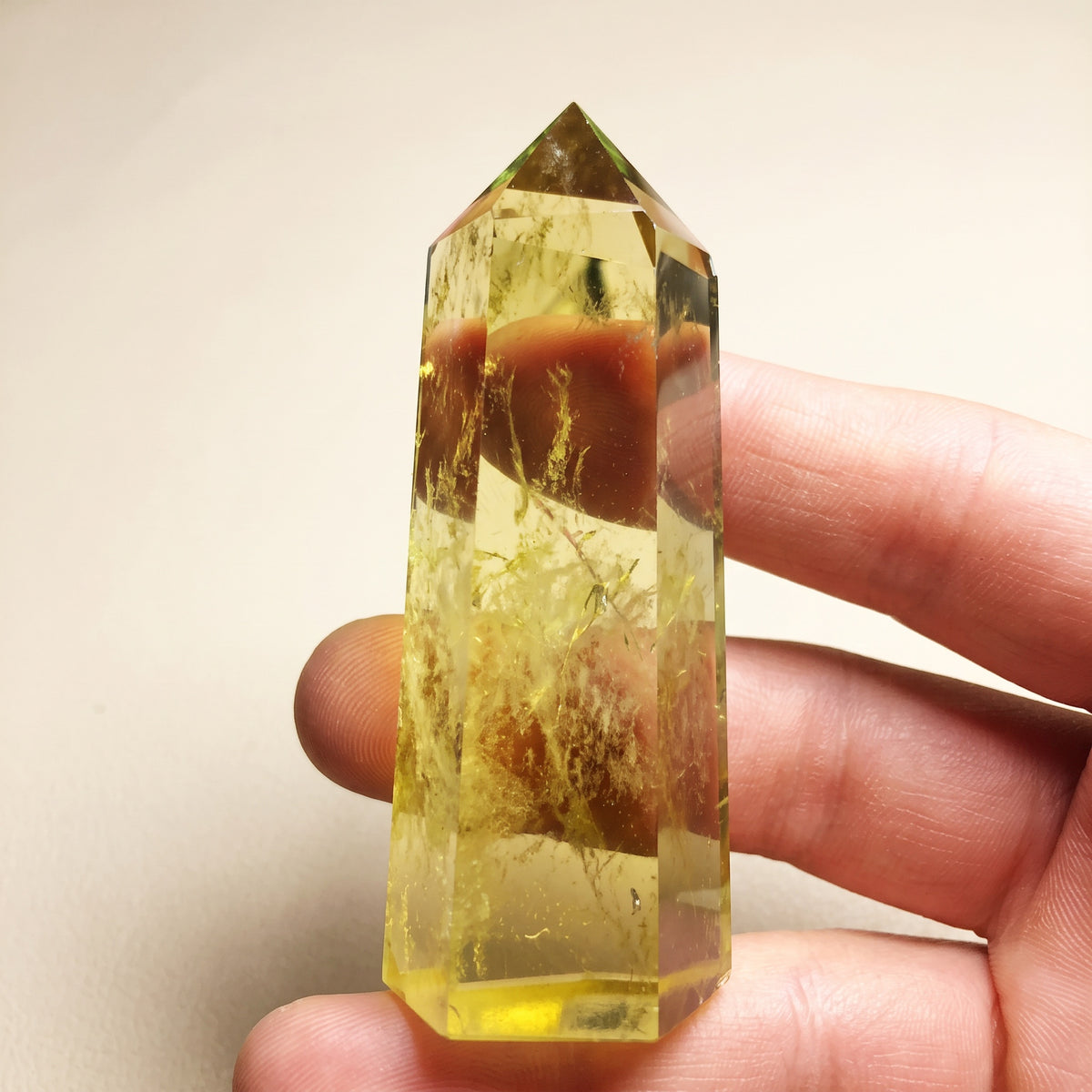 Real photo of a natural citrine tower held in hand