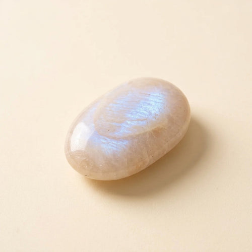 Polished moonstone palm stone with soft blue sheen